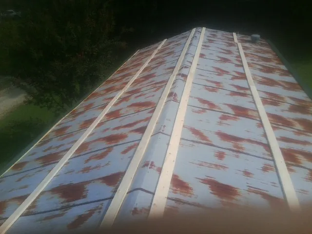 Rusted metal roof panels with new wood purlins before replacement — Storm Damage Roof Repair in Mount Pocono by Roofing Brothers