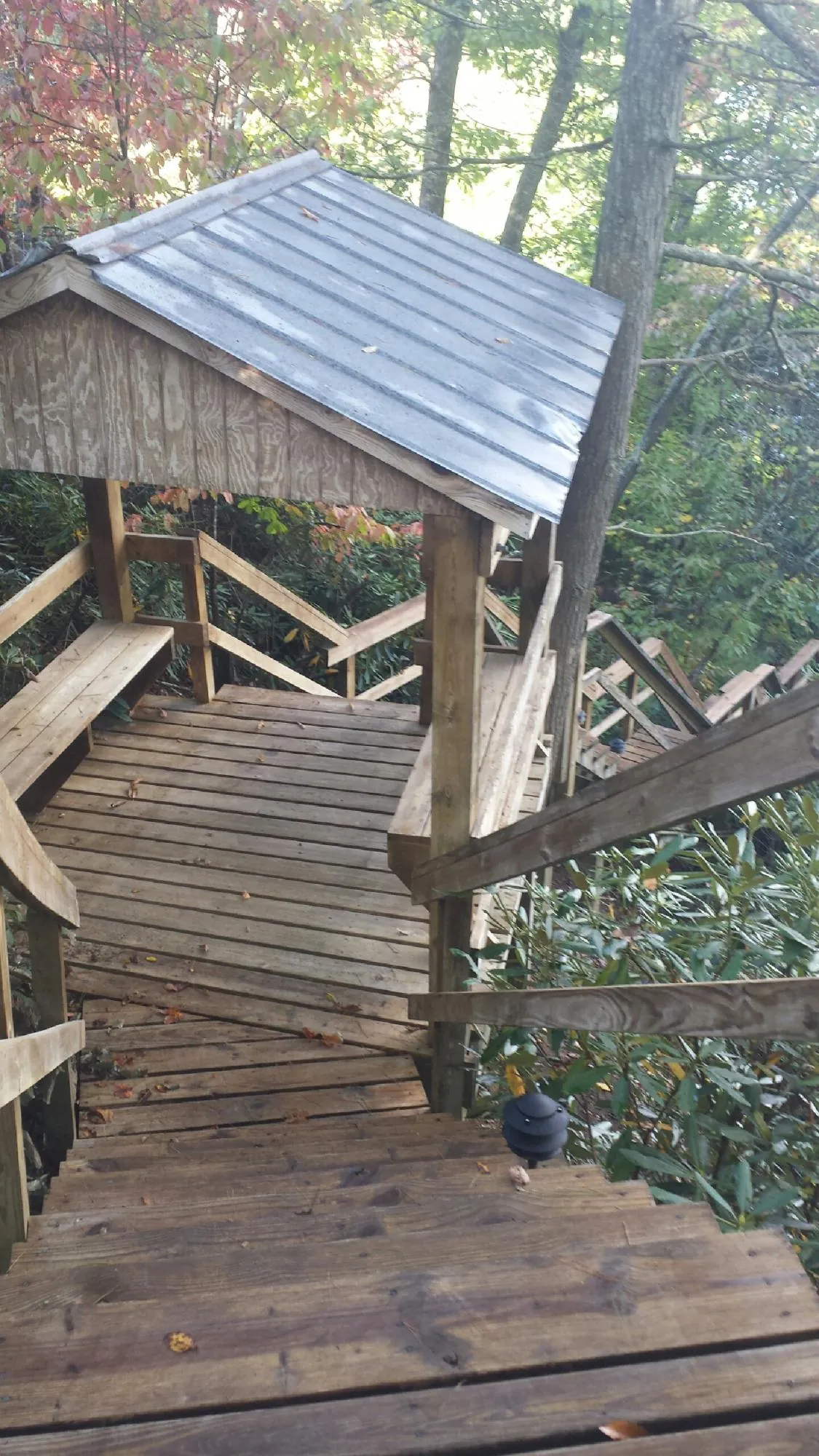 Metal roofed shelter over wooden steps on a wooded walkway — Skylight Repair & Installation work by our crew in Mount Pocono